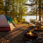 Campsite on lake in northern Minnesota with campfire at sunset