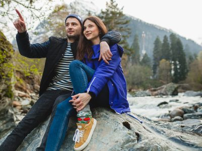 youngyoung hipster beautiful couple in love walking on a rocks at river in winter forest, jeans, warm coat, sneakers, smiling, having fun, traveling, hiking, vacation, love, romance hipster beautiful couple in love walking on a rocks at river in winter forest, jeans, warm coat, sneakers, smiling, having fun, traveling, hiking, vacation, love, romance